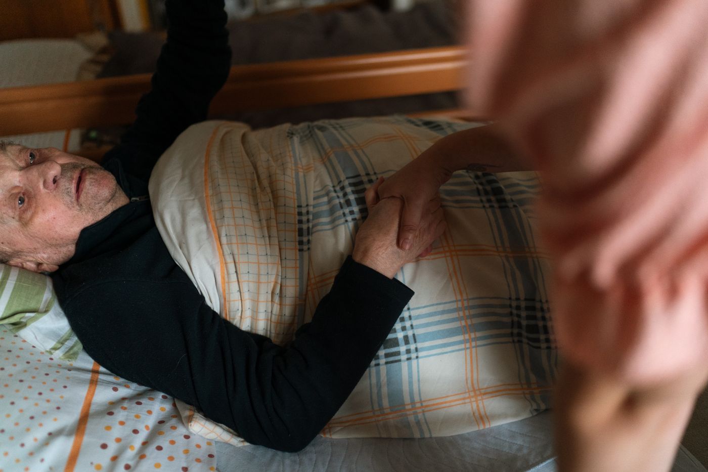 A carer holding a client's hand